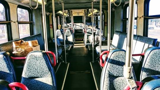 Sun shining across the interior of an empty King County Mtero bus. 