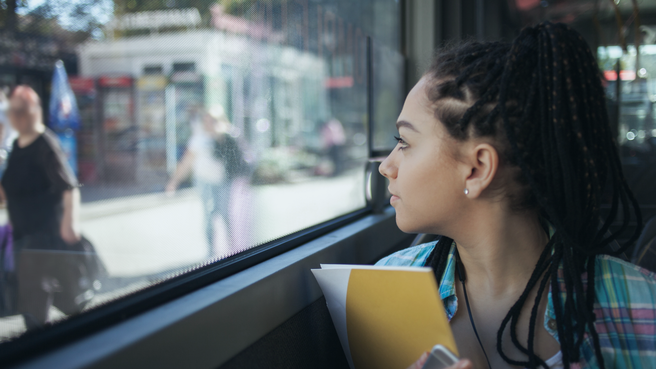 Image of a teen girl looking out a bus window with overlaid text: Youth Perspectives on Transit: Increasing Access and Utilization