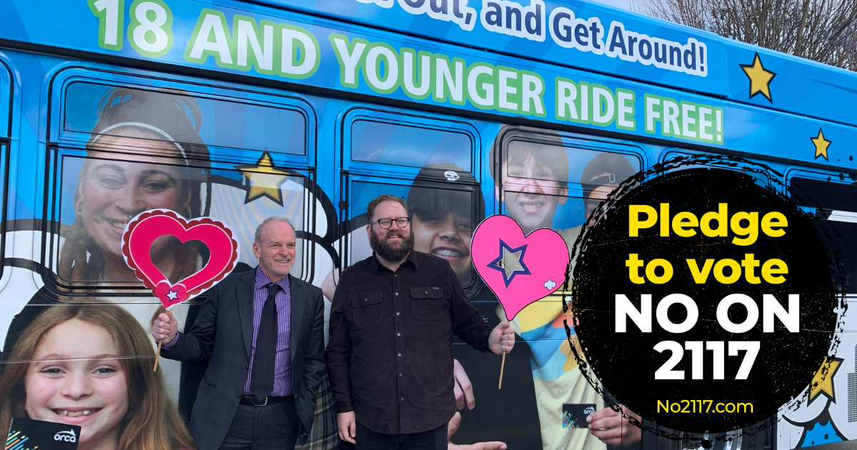 Image of Marko Liias and Jake Fey in front of a bus advertising Youth Ride Free with the No on 2117 logo