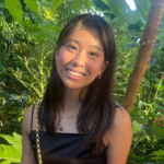 Image of a young woman with trees in the background. 