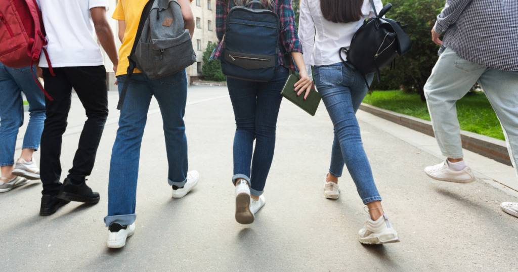 Students shown walking to school from behind. 