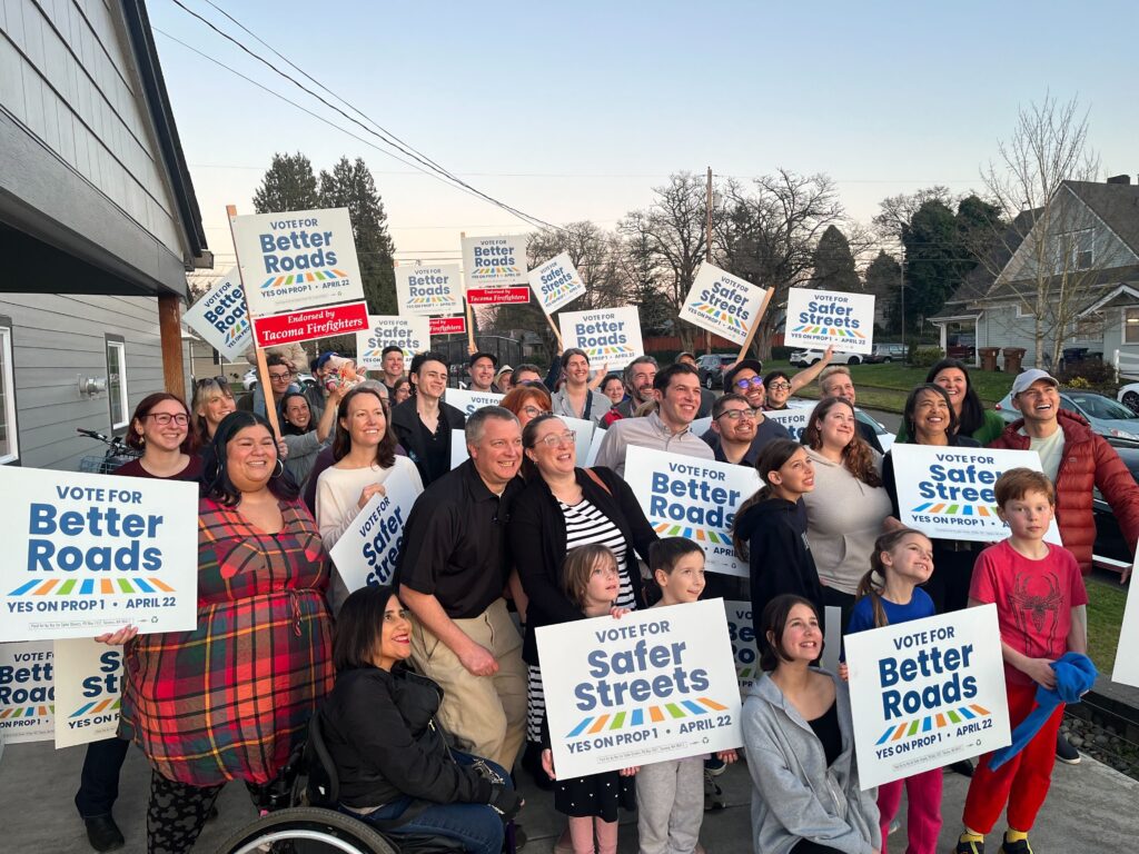 People of all ages and abilities hold signs that say 