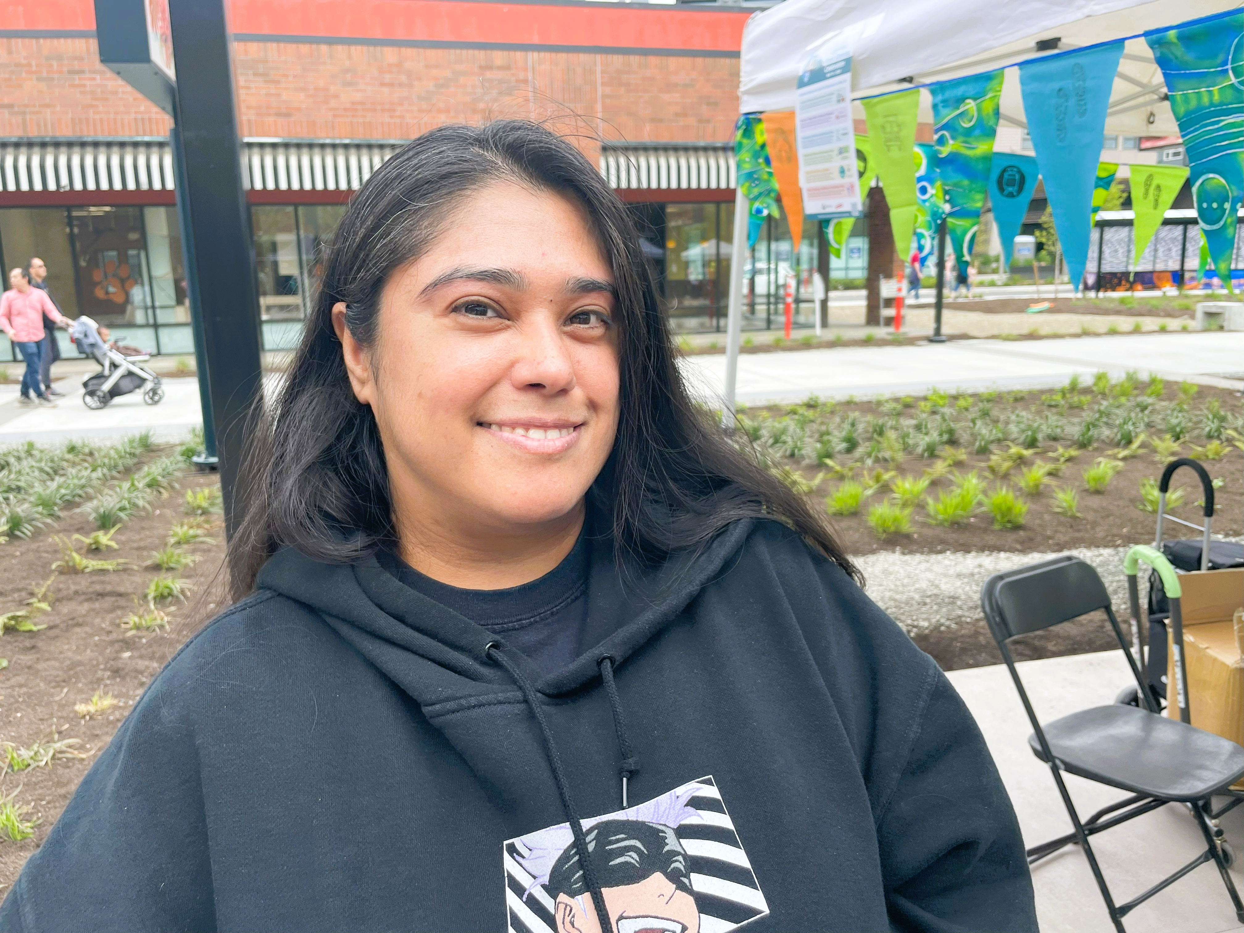 Genesis-Downtown-Redmond A young woman in a black hoodie smiles for the camera.