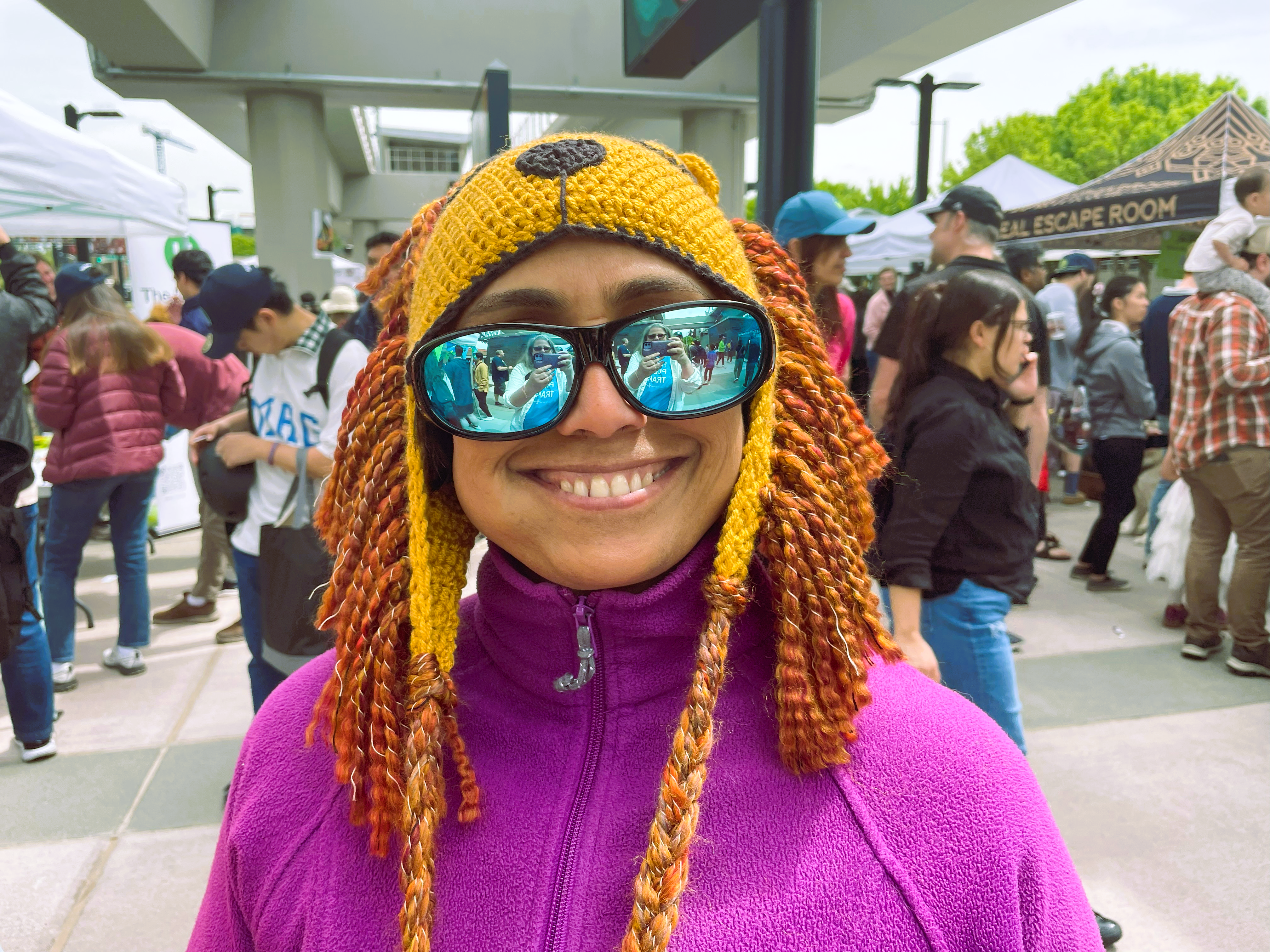 Rivender A woman in a knitted lion hat and sun glasses smiles for the camera.