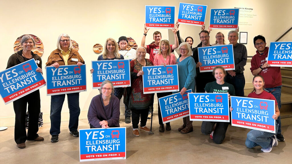 Community members hold signs that say 