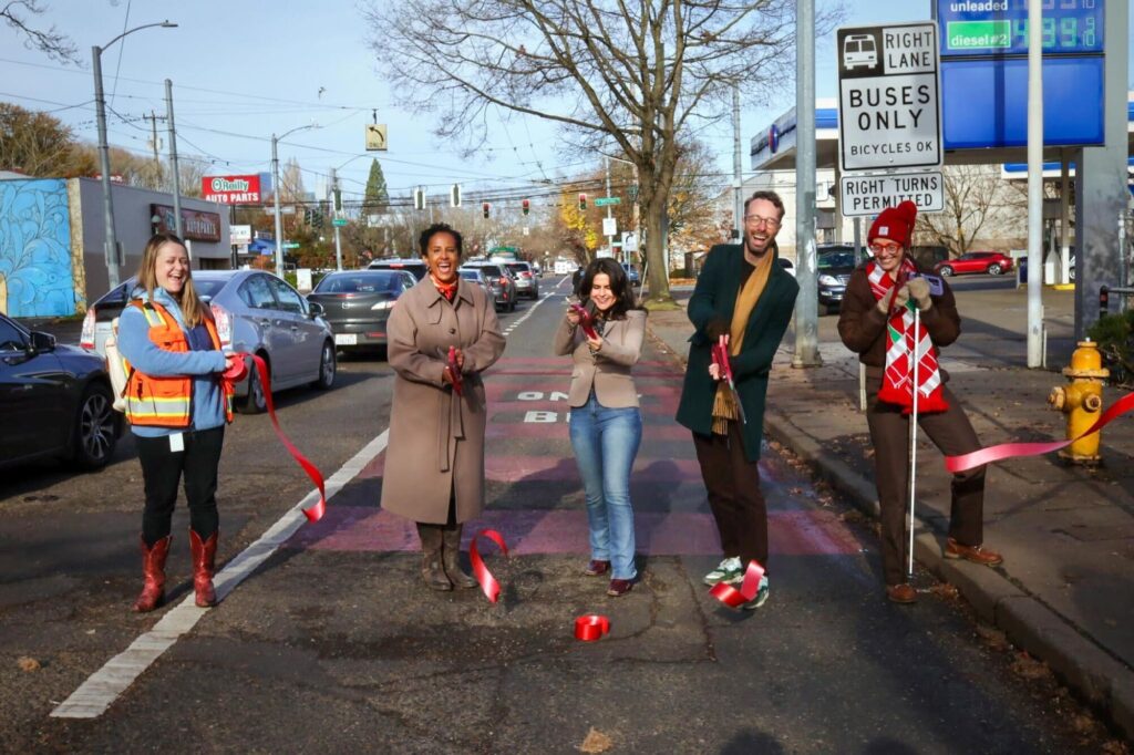 SDOT Interim Director Adiam Emery, Seattle City Councilmember Alexis Mercedes Rinck, Transportation Choices Coalition Director Kirk Hovenkotter, Anna Zivarts with the Nondrivers Alliance, and SDOT staff cut the ribbon on the Rainier Ave S bus lane on November 19, 2025