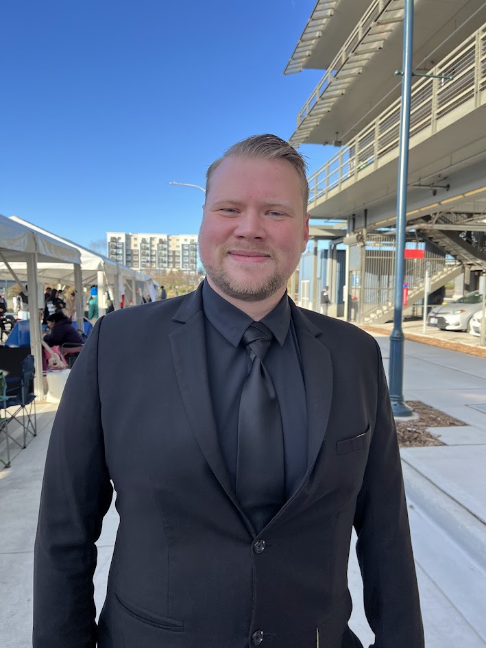 A smiling man in a black suit