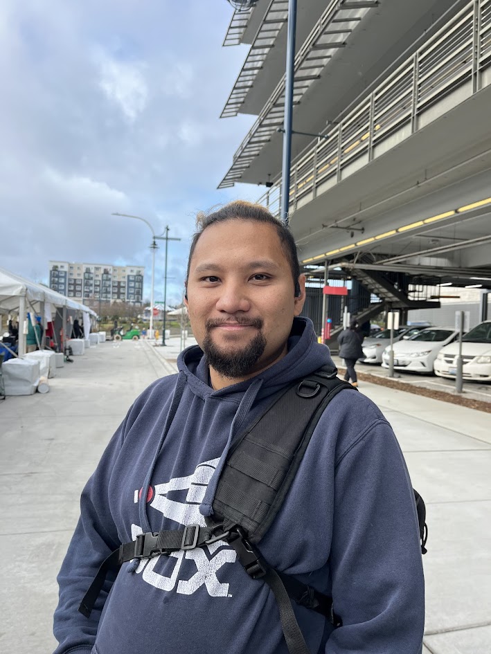 A smiling man in a blue hoodie