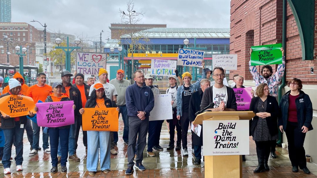 Four people stand on the steps of the capitol building in Olympia.