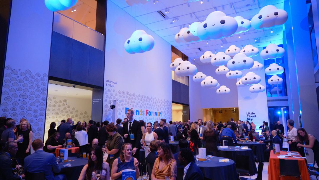 Tuxes & Trains attendees seated in rows under the hanging tree sculpture in the Seattle Art Museum. 
