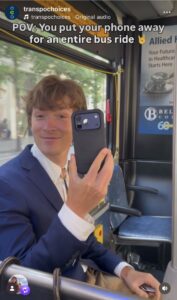 A smiling man holds up his phone on the bus. Text: "POV: You put your phone away for an entire bus ride"