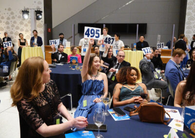 Guests hold up their bidder numbers to join the raffle.